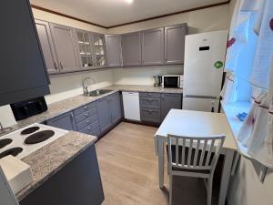 a kitchen with a white refrigerator and a white table at Rent Apartament Lofoten in Svolvær