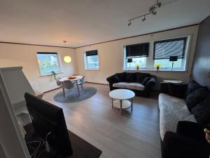 a living room with a couch and a tv at Rent Apartament Lofoten in Svolvær