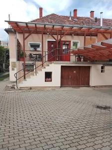 a large house with a porch and a driveway at Rita apartman in Szombathely