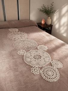 a bed with a white embroidered pattern on it at "Ventana del Guadalquivir " in Baeza