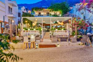 a patio with chairs and tables in a city at night at Kalkan Port Hotel in Kaş