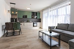 a living room with a couch and a table at Grey Suites Pécs in Pécs