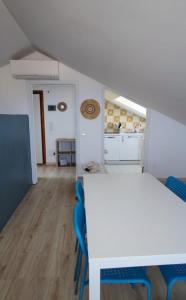 a room with a white table and blue chairs at La Petite in Cogoleto