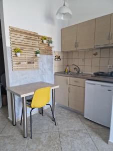 a kitchen with a table and a yellow chair at VILLA KETI in Leptokarya