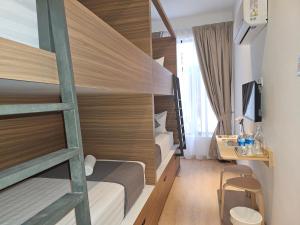 a room with two bunk beds and a desk at ClubRock Perlis Signature Hotel in Kaki Bukit