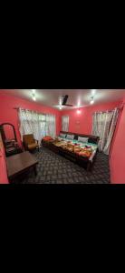 a bedroom with pink walls and a bed and a chair at Derban guest house in Srinagar