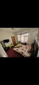a bedroom with a bed and a couch and a window at Derban guest house in Srinagar