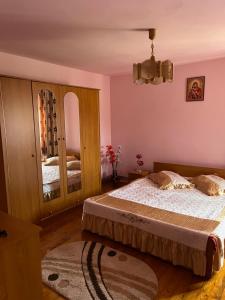 a bedroom with two beds and a mirror at Cazare Sandy in Novaci-Străini