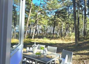 a table and chairs with a view of a forest at Strandhaus Rügen 243 in Baabe