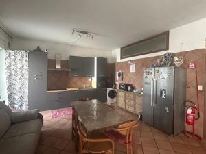 a kitchen with a refrigerator and a table in it at Appartamento con Stanze Condivise in Busto Garolfo