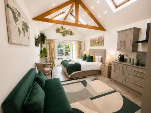a living room with a green couch and a bed at The Garden Hideaway Central Corbridge in Corbridge