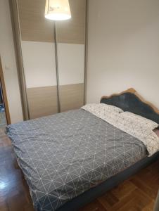 a bedroom with a bed with a gray comforter at River & Garden Apartment in Trebinje