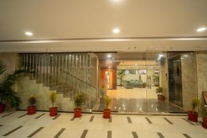 a lobby with a staircase and potted plants at Magnet Hotel in Vijayawāda