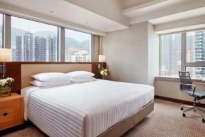 a hotel room with a bed and a desk and windows at Courtyard by Marriott Hong Kong in Hong Kong +16 photos