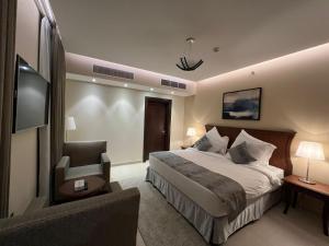 a hotel room with a bed and a chair at فندق الضليعة in Unayzah