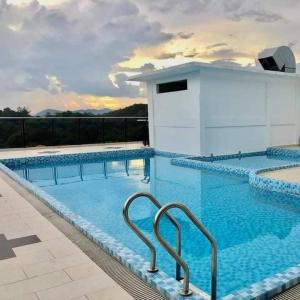 a large swimming pool with blue water at Amin Studio Apartment Pool And Netflix in Gua Musang