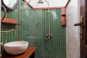 a green tiled bathroom with a sink and a shower at Kalkan Port Hotel in Kaş