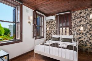 a porch with a white bed and windows at Kalkan Port Hotel in Kaş
