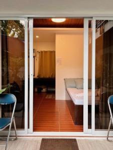 a sliding glass door with a bed in a room at Alicia's Guest House in Butuan