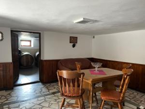 a dining room with a table and chairs and a couch at Cazare Sandy in Novaci-Străini