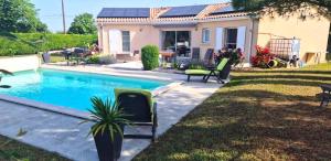 a backyard with a swimming pool and a house at La maison dans les vignes in Châteauneuf-sur-Charente