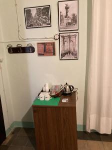 a room with a table with a tea kettle and pictures on the wall at La Casa dellAmericano - Casa d'epoca anni '30 in Aliano