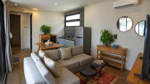 a living room with a couch and a kitchen at Amandalay Hotel & Villas in Karimunjawa