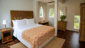 a bedroom with a large bed and two windows at Amandalay Hotel & Villas in Karimunjawa
