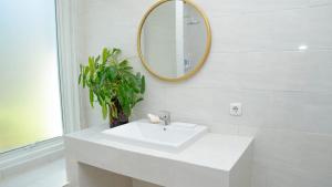 a white bathroom with a sink and a mirror at Amandalay Hotel & Villas in Karimunjawa