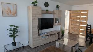 a living room with a flat screen tv on a wall at Magaslak Apartman in Kaposvár