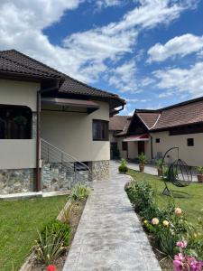 a house with a walkway in front of a yard at Cazare Sandy in Novaci-Străini