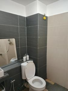 a bathroom with a toilet and a sink and a mirror at Amin Studio Apartment Pool And Netflix in Gua Musang