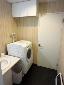 a bathroom with a washing machine and a sink at Lei Toya in Sobetsu +23 photos