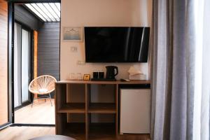 a room with a desk with a television on the wall at Blue Heaven Seaside in Borsh