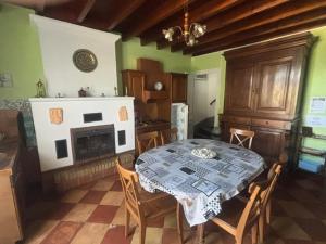 a dining room with a table and a fireplace at Le logis d Adrien in Saint-Magne-de-Castillon