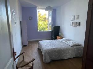 a bedroom with a bed and a window at Le logis d Adrien in Saint-Magne-de-Castillon