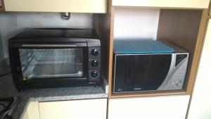a microwave and a toaster oven in a kitchen at Appartamento Ca' Lela in Marghera