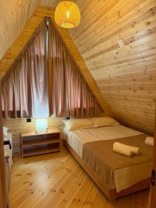 a bedroom with a bed in a wooden cabin at Horizon Mestia - Premium Chalets With Panoramic Views in Mestia