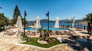 a resort with a pool and chairs and umbrellas at Les Terrasses De Selimiye in Selimiye