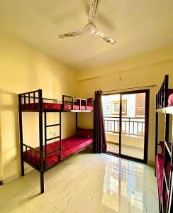two bunk beds in a room with a window at Joy Suites and Hostel in Pune