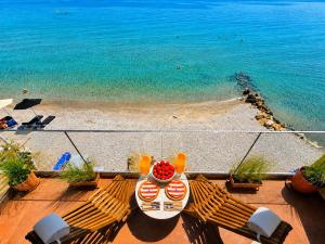 a table with a bowl of fruit on a balcony overlooking the beach at Ca' Mare luxury suite in Mesongi