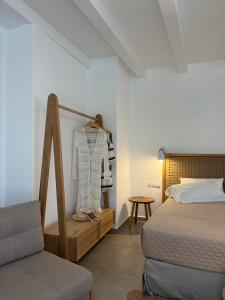 a bedroom with a bed and a dresser and a chair at Blue Paradise Apartments in Naxos Chora