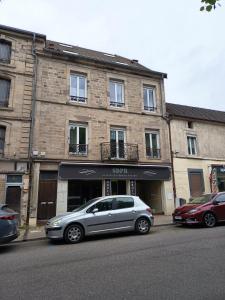 a silver car parked in front of a building at Charmant T2 Cosy - Sous les toits in Luxeuil-les-Bains