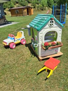 a toy car and a toy house on the grass at Baita Mael in Armeno