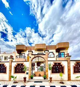 a large building with an arch and a cloudy sky at The Castle Hotel & studios in Dahab