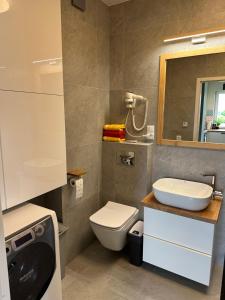 a bathroom with a toilet and a sink and a mirror at Apartamenty Wichrowa in Żywiec +19 photos