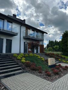 a house with stairs and flowers in front of it at Apartamenty Wichrowa in Żywiec
