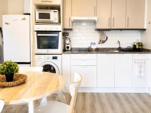 a kitchen with a wooden table and white cabinets at Fenals Calm - con piscina in Lloret de Mar