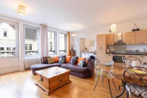 a living room with a couch and a table at La Suite des Épinoches - Parking Privé in Mâcon