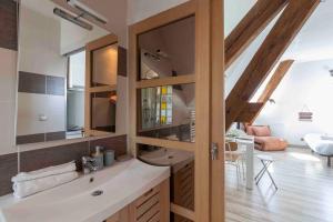 a bathroom with a sink and a mirror at La Suite des Épinoches - Parking Privé in Mâcon +96 photos